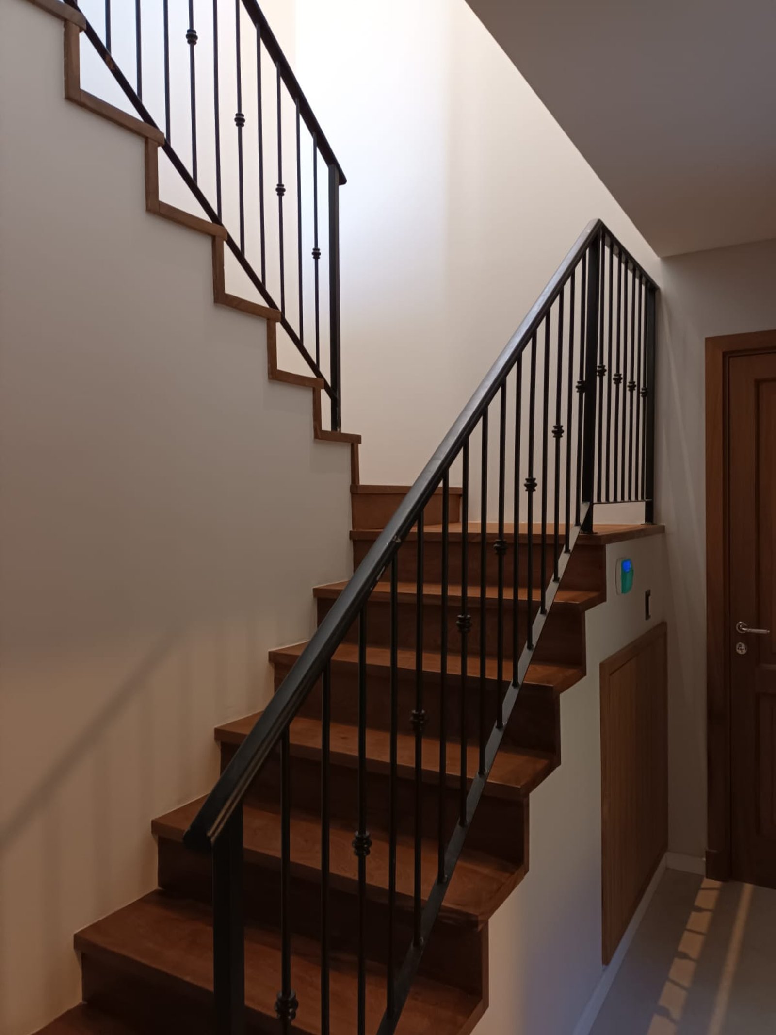 Escalera moderna interior con barandillas negras y madera natural — proyecto CASA AL120, por DIB OBRIST Arquitectas, en Av. Jorge Newbery 8800